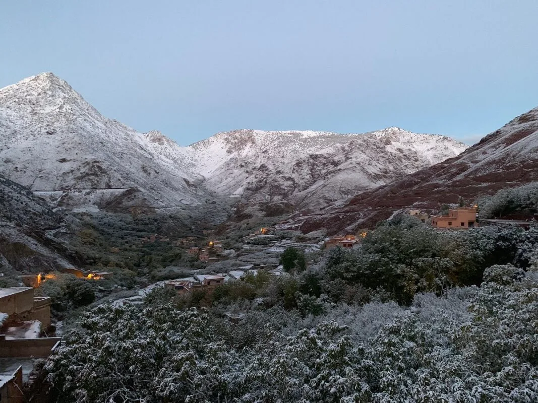 Hikers on a rocky trail overlooking Moroccan mountain valleys