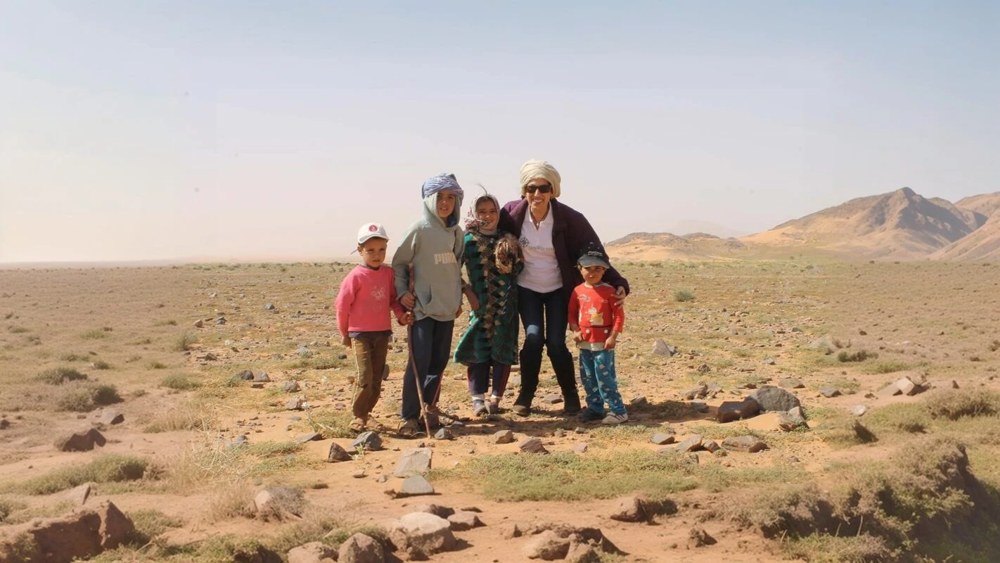 Siroco Tours team with local children in the Moroccan desert