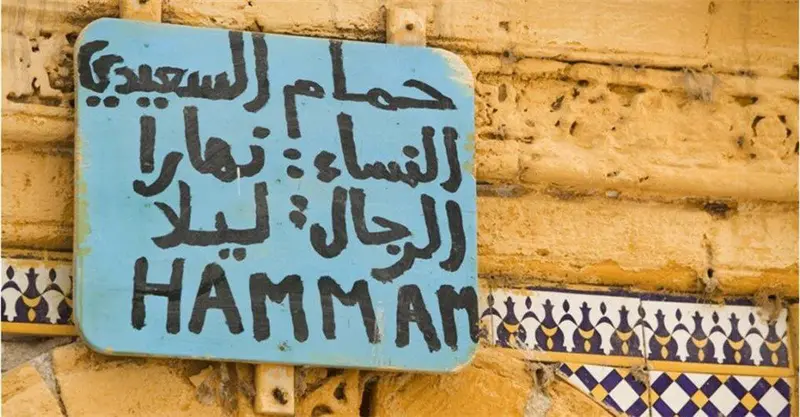 Arabic calligraphy and street signs in a Moroccan medina
