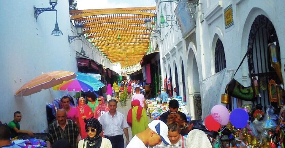 Traveller walking confidently through a Moroccan street with local life around