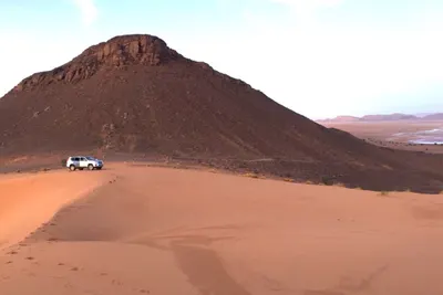 4x4 cresting a Sahara dune ridge at golden hour