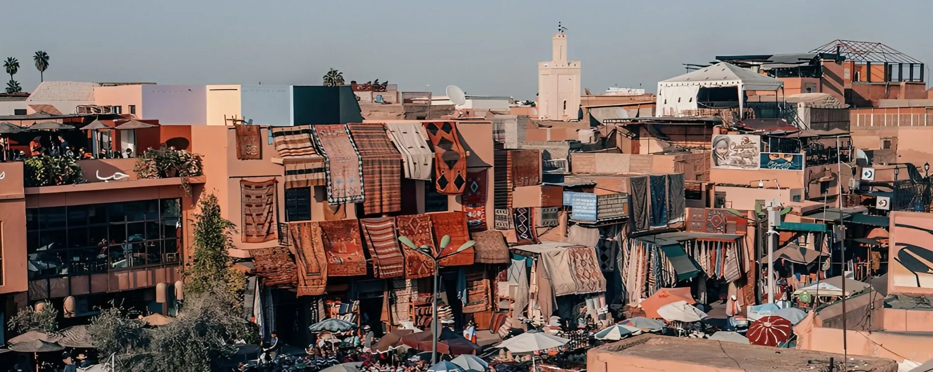 Colourful carpets draped from ochre rooftops above a busy medina market