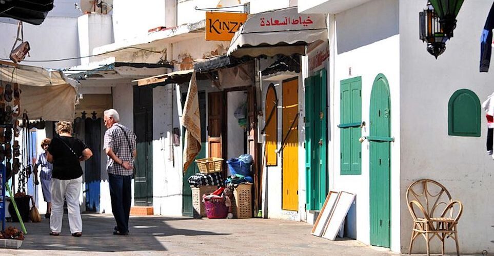 Tourists walk around the medina of Assilah